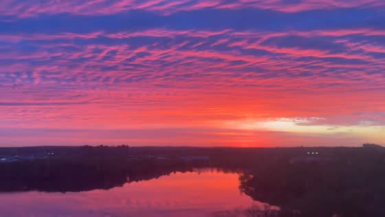 Vibrant sunrise reflects over river in Cambridge, Massachusetts, USA