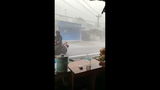 Motorcyclist struggles against powerful winds during storm in Purbalingga, Indonesia