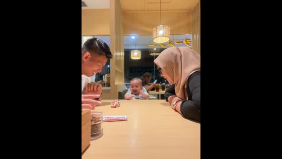 Joyful interaction: parents engage baby with car toy