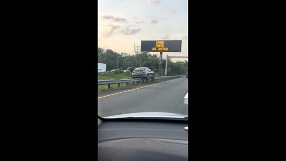 Car hangs off guardrail in unusual road scene in Philadelphia, Pennsylvania, USA