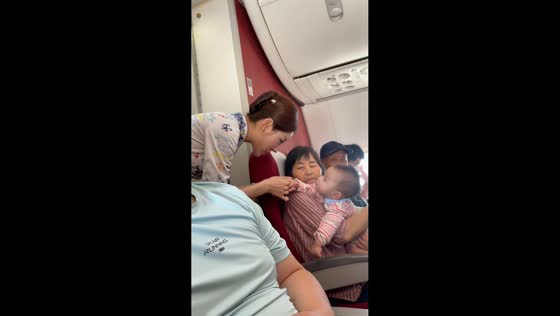 Baby refuses to let go of flight attendant's fingers in Anhui, China