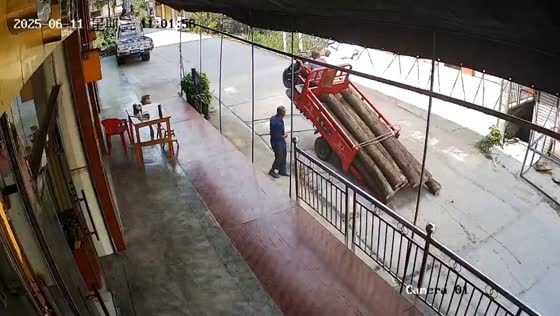 Overloaded tricycle lifts front wheel and spills logs in Sichuan, China