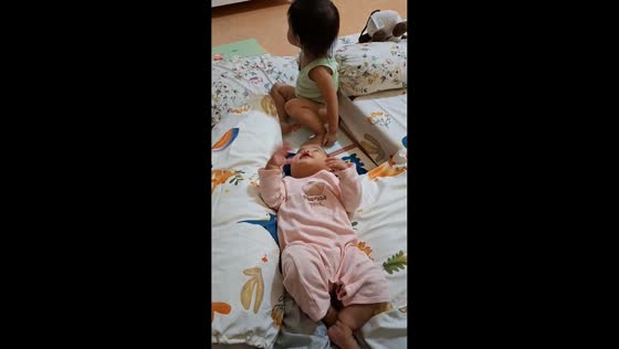 Toddler’s playful hug leads to funny sibling moment in Purwokerto, Java, Indonesia