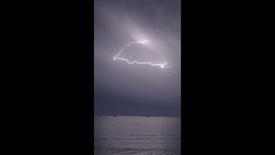 Spectacular chain of lightning stretches across sky over Mediterranean Sea in Juan-les-Pins, France