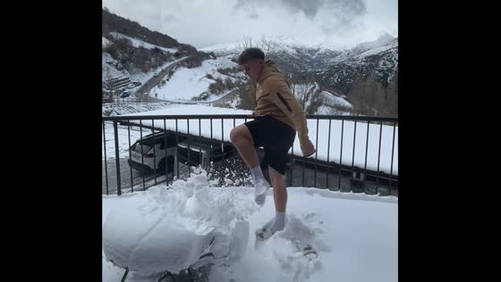 Person accidentally hits table while kicking snow off in Madrid, Spain