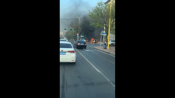 Burning car sends thick smoke into air in Liaoning, China