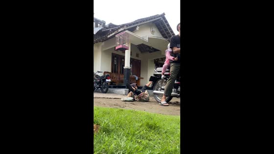 Man attempts wheelie, niece falls but quickly recovers in Yogyakarta, Indonesia