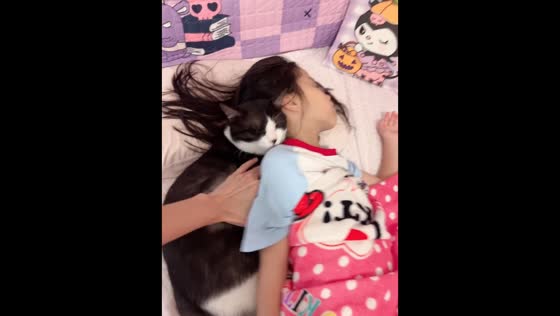 Cat refuses to leave sleeping girl's side in Guangdong, China