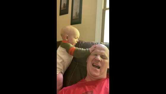 Dad and son share playful antics on the couch in Waverly, Ohio, USA