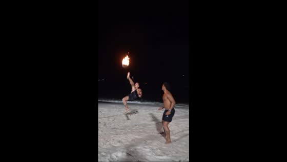 Friends play fiery beach ball game in Niterói, Brazil