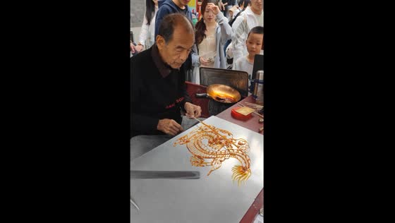 Person in Tianjin creates dragon with melted sugar