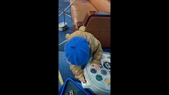 Child helps operate a pool ball polishing machine in Heilongjiang, China