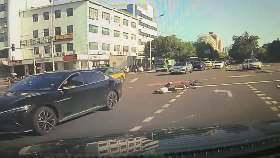 Cyclist crashes into car while crossing intersection in Beijing, China