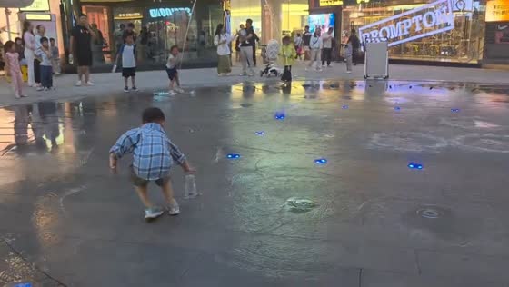 Child watches fountain lift cups into the air in Shaanxi, China