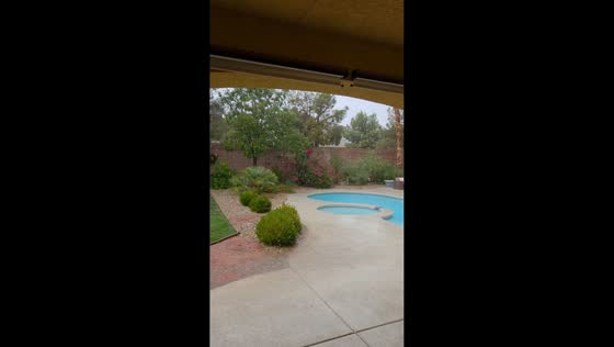 Hail and rain sweep across residential backyard in Las Vegas, USA