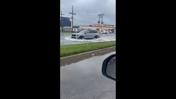 Vehicles drive through flooded streets in Kenner, Louisiana, USA