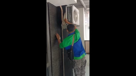 Man slips from chair while cleaning air conditioner unit in Cibubur, Java, Indonesia