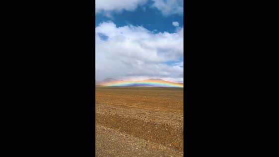 Rare low rainbow over barren landscape in Shanxi, China