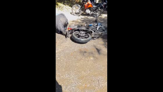 Motorcycle rider slips near end of flooded bridge crossing in Guaratuba, Brazil