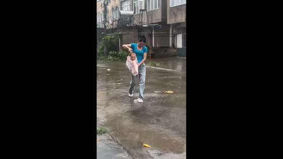 Woman carries child inside tote bag to keep them dry in Anhui, China