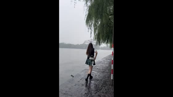 Phone slips and falls into riverside water during rainy walk in Anhui, China