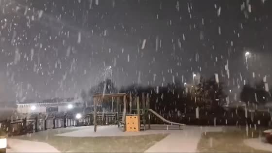 Evening snow showers blanket a playground in Warrington, England, UK