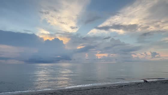 Golden twilight illuminates storm clouds over the ocean in Dania Beach, Florida, USA