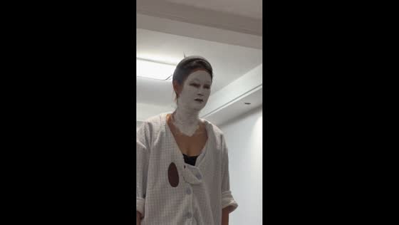 Woman wearing a scary white facial mask during a conversation in Zhejiang, China