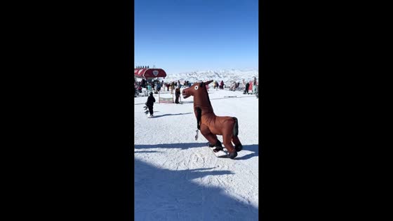 Snowboarder in inflatable horse costume hilariously slides down snowy slope in Xinjiang, China