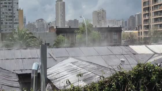 Steam rises from rooftops as sunlight evaporates rainwater in Santiago, Chile