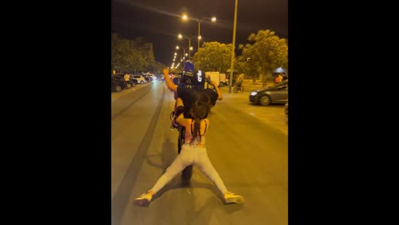 Motorcycle passenger nearly falls during wheelie on road