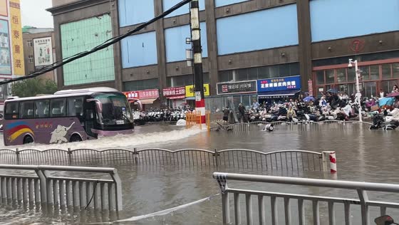Bus pushes water waves over submerged motorcycle in Henan, China