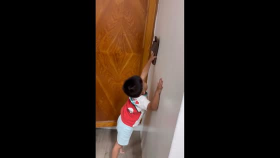 Boy chases cockroach in playful indoor scene in Anhui, China