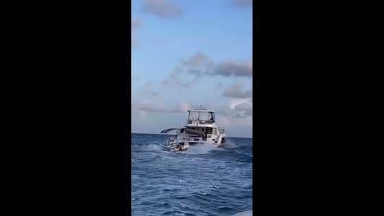 Small boat violently rocks while tied to larger vessel in Baie-Mahault, Guadeloupe