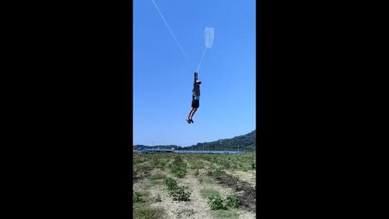 Strong winds lift man while flying kite in Shanghai, China