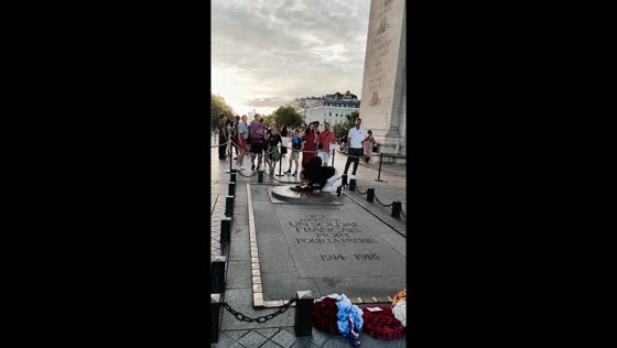 Man lights cigarette using eternal flame at Arc de Triomphe in Paris, France