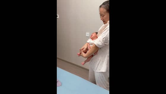 New dad practices holding a baby on the family cat in Jiangsu, China
