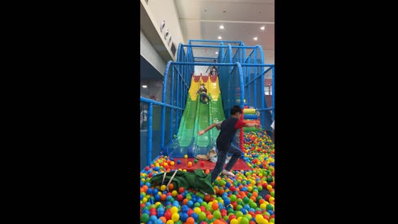 Joyful aunt protectively embraces niece on slide in San Fernando, Philippines