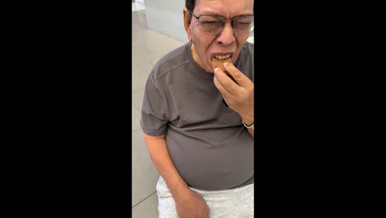 Man struggles with cookie on dentures in Cebu, Philippines