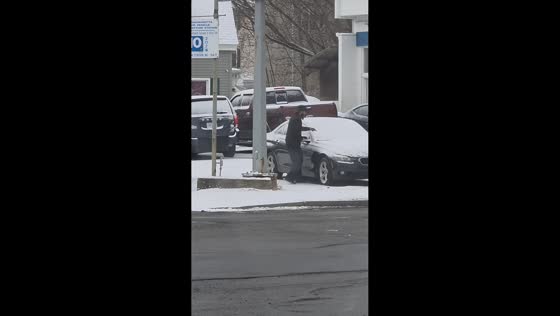 Man draws smiley faces on snow-covered cars in Peabody, Massachusetts, USA