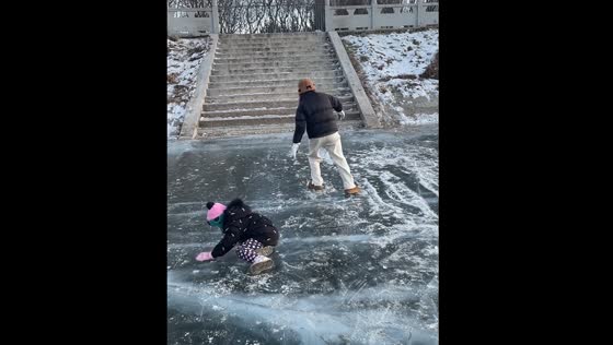Person slides backwards on frozen lake in Jilin province, China