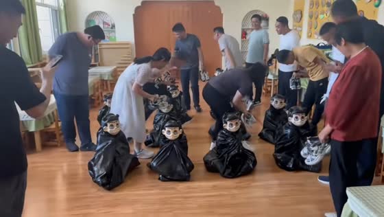 Fathers try to identify their masked children sitting on the floor in Shandong, China