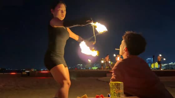 Fire dancer lights cigarette during performance in Hainan, China