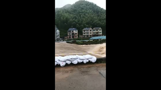 Emergency sandbag barrier protects riverside village in Zhejiang, China