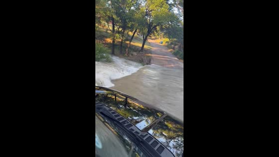 Vehicle attempts to cross storm-flooded road in Palisades, Texas, USA
