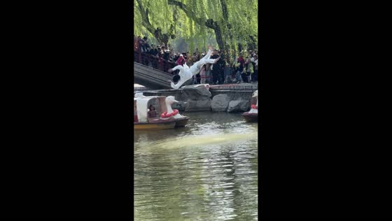 Performer jumps along rope over water during spring event in Hebei, China