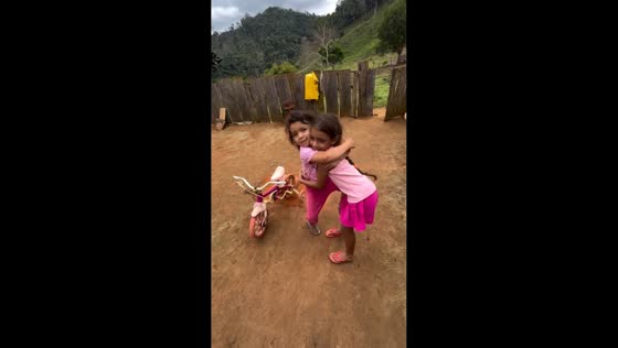 Girls lose balance during playful hug in Rio de Janeiro, Brazil