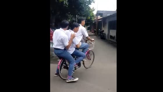Friends riding one bicycle leads to bent wheels in Ponorogo, Indonesia