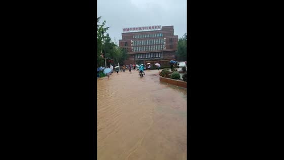 Students wade through flooded streets amid heavy rain in Sichuan, China