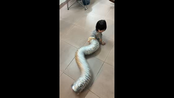 Toddler playfully crawls inside flexible duct hose in Guangdong, China